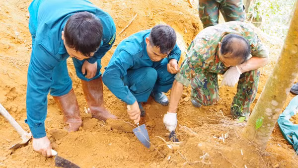 Lực lượng chức năng khai quật, tìm kiếm hài cốt liệt sĩ Lê Tước. (Ảnh: DUY ĐỨC)