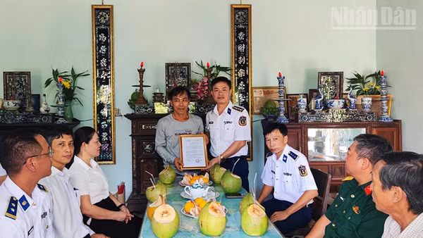 Đại tá Nguyễn Tiến Đức trao quyết định phụng dưỡng Mẹ Việt Nam Anh hùng Lâm Thị Hoạnh. (Ảnh: NAM TRUNG)