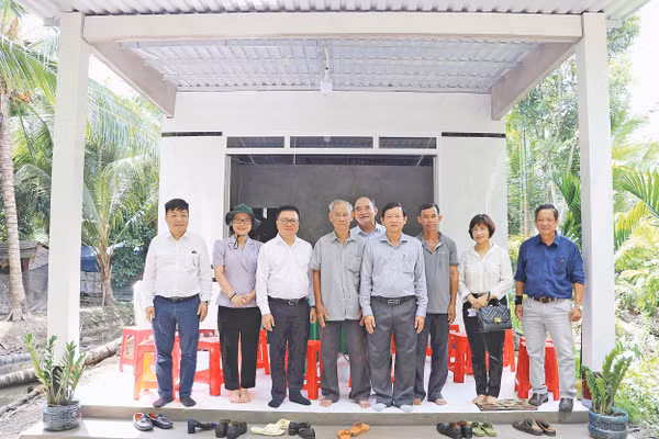 Lãnh đạo Báo Nhân Dân chụp ảnh lưu niệm trong một lần tặng quà hỗ trợ xây dựng nhà “Đại đoàn kết” khu vực Đồng bằng sông Cửu Long. Ảnh: BÁ DŨNG
