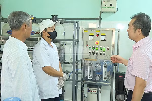 Anh Trần Văn Được bên cơ sở sản xuất nước tinh khiết của gia đình. (Ảnh: KIỀU DUYÊN)