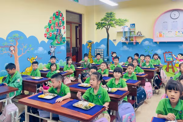 Bữa ăn bán trú đầu tiên của học sinh Trường tiểu học và trung học cơ sở Trần Quốc Toản, phường Kinh Bắc. ( Ảnh: A.T)