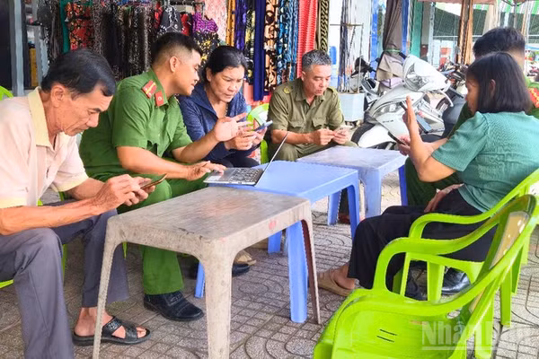 Cán bộ, chiến sĩ Công an phường Vị Thanh giải quyết thủ tục hành chính cho nhân dân tại cơ sở. (Ảnh: VĂN ÚT)