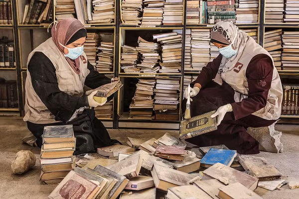 Các tình nguyện viên Palestine làm công tác phục chế ban đầu đối với số sách và bản thảo bị hư hại tại thư viện của Thánh đường Hồi giáo Lớn Omari tháng 2/2026. Ảnh | Omar AL-Qattaa / AFP/Getty Images