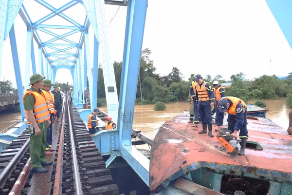 Lực lượng chức năng của Công an tỉnh Quảng Trị dùng thiết bị cắt sà-lan để cẩu ra khỏi khu vực cầu đường sắt.
