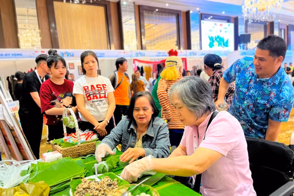 Khách tham quan trải nghiệm làm bánh giò tại gian hàng của anh Đức Vương.