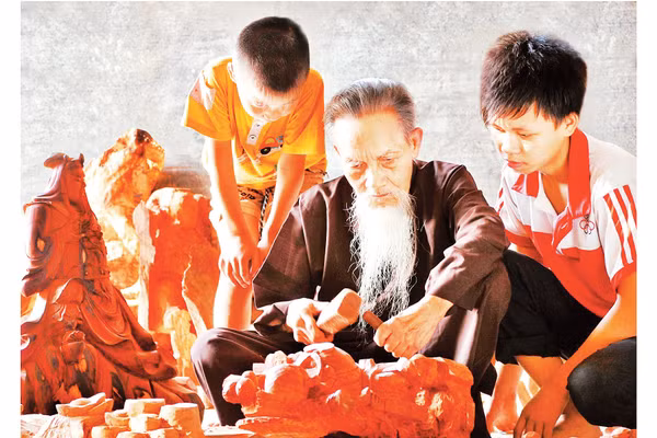 Nghệ nhân làng nghề gỗ mỹ nghệ Thiết Úng truyền nghề cho con, cháu. Ảnh: Đỗ Phong 