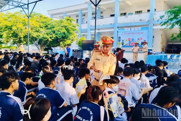 Cán bộ Phòng Cảnh sát giao thông Công an tỉnh Cà Mau phát tờ rơi tuyên truyền cho các em học sinh tại trường Trung học phổ thông Sông Đốc (xã Sông Đốc, tỉnh Cà Mau).