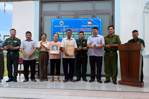 Đại diện Ban Chỉ huy Bộ đội Biên phòng tỉnh Đắk Lắk và cấp ủy, chính quyền địa phương, cùng các đơn vị tặng ảnh Bác Hồ và biểu trưng Nhà Đại đoàn kết cho gia đình ông Ngô Văn Giáp. (Ảnh: NGUYỄN LÂN)