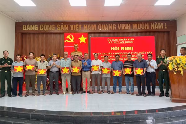 Đại diện các đơn vị và địa phương trao cờ Tổ quốc tặng các ngư dân tại xã Tuy An Đông. (Ảnh: Ngọc Lân)