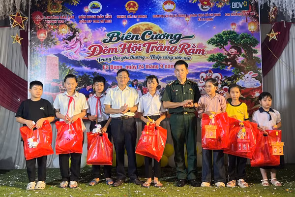 Đại diện Chỉ huy Đồn Biên phòng Cửa khẩu Đắk Ruê và lãnh đạo cấp ủy, chính quyền địa phương trao quà tặng các em thiếu nhi tại xã Ea Bung. (Ảnh: NGỌC LÂN)
