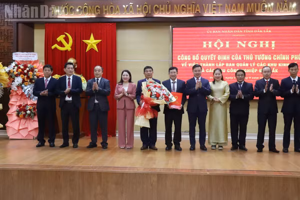 Chủ tịch Ủy ban nhân dân tỉnh Đắk Lắk Đỗ Hữu Huy trao Quyết định của Thủ tướng Chính phủ thành lập Ban Quản lý các khu kinh tế và các khu công nghiệp Đắk Lắk và tặng hoa chúc mừng. (Ảnh: Công Lý)