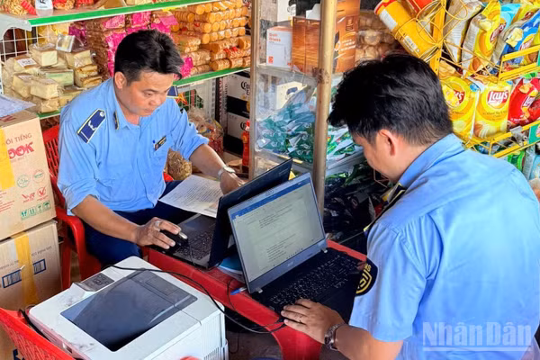 Lực lượng Quản lý thị trường Tây Ninh lập biên bản hộ kinh doanh thuốc lá nhập lậu không xuất trình được hóa đơn, chứng từ hay bất kỳ giấy tờ liên quan. (Ảnh: THANH PHONG)