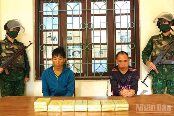 Hai đối tượng phạm tội về ma túy cùng tang vật do Bộ đội Biên phòng tỉnh Điện Biên phát hiện, bắt giữ. (Ảnh: LÊ LAN)
