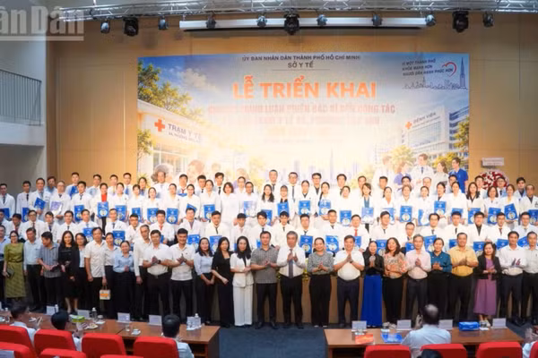 Lãnh đạo Thành phố Hồ Chí Minh và các đại biểu chụp ảnh cùng 79 bác sĩ luân phiên về trạm y tế. (Ảnh: KHANG ANH)