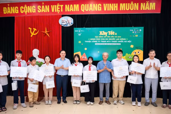 Ông Ngô Việt Anh, Giám đốc Trung tâm Phát triển Truyền thông, Báo Nhân Dân; ông Tống Văn Nga, Thành viên độc lập Hội đồng Quản trị Công ty cổ phần Xây dựng Coteccons và ông Phạm Ngọc Toàn, Ủy viên Thường vụ Đảng ủy, Phó Tổng Giám đốc Công ty TNHH Một thành viên Thoát nước Hà Nội trao học bổng cho các em học sinh. (Ảnh: VIỆT HÀ)