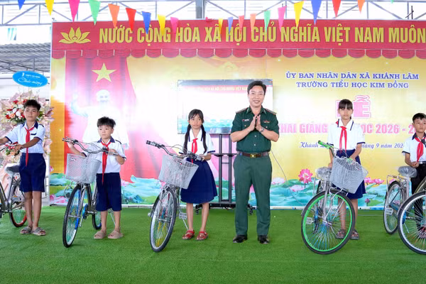 Đại tá Phạm Minh Giang, Bí thư Đảng ủy, Chính ủy Bộ đội Biên phòng Cà Mau, tặng xe đạp động viên các em học sinh tại Trường tiểu học Kim Đồng (xã Khánh Lâm, tỉnh Cà Mau). (Ảnh: HOÀNG TÁ)