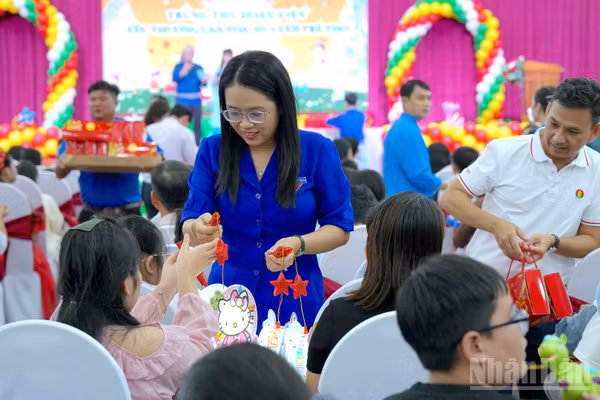 Tặng quà cho các cháu thiếu nhi là con công nhân, viên chức, lao động tại buổi họp mặt. (Ảnh: HỮU TÙNG)