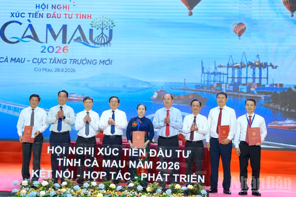 Lãnh đạo tỉnh Cà Mau trao biên bản ghi nhớ cho các nhà đầu tư trước sự chứng kiến của Phó Thủ tướng Chính phủ Hồ Quốc Dũng (thứ 4 từ trái qua) và Bí thư Tỉnh ủy Cà Mau Nguyễn Hồ Hải (thứ 4 từ phải qua). (Ảnh: HỮU TÙNG)