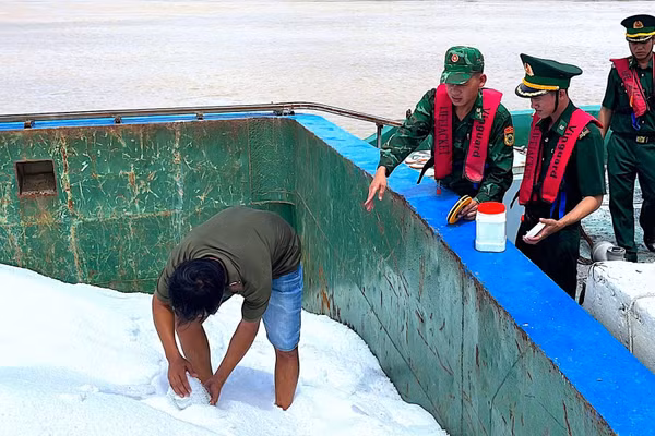 Lấy mẫu số phân urê trên sà lan LA-08708 giám định theo quy định của pháp luật. (Ảnh: HOÀNG TÁ)