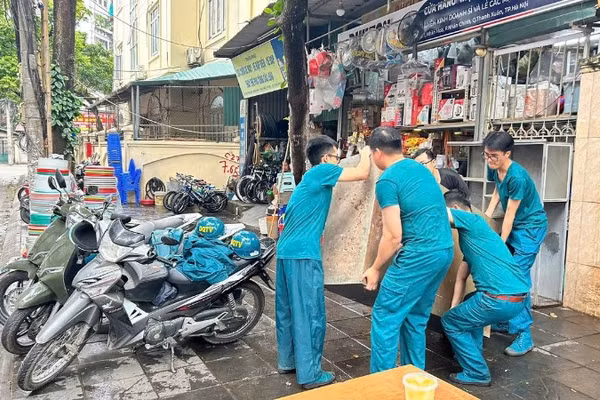 Lực lượng chức năng phường Thanh Xuân hỗ trợ người dân di chuyển đồ đạc đến nơi tạm cư.