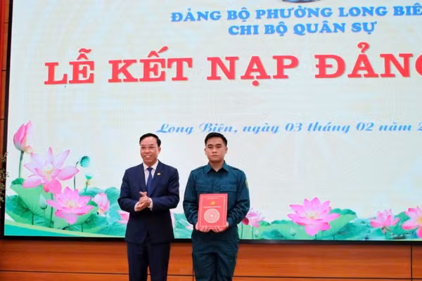 Bí thư Đảng ủy phường Long Biên trao quyết định kết nạp Đảng cho tân binh. (Ảnh: MINH PHÚC)