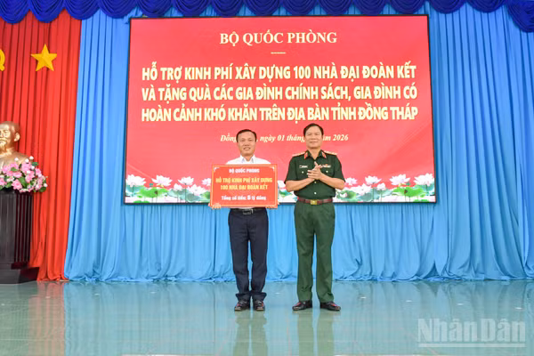 Đại tướng Nguyễn Tân Cương trao bảng tượng trưng của Bộ Quốc phòng hỗ trợ kinh phí xây dựng 100 nhà Đại đoàn kết trên địa bàn tỉnh Đồng Tháp. (Ảnh: CHÍ PHÚC)