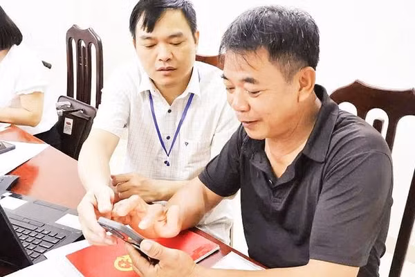 Cán bộ Trung tâm phục vụ hành chính công xã Thung Nai hướng dẫn người dân thôn Thống Nhất làm thủ tục.