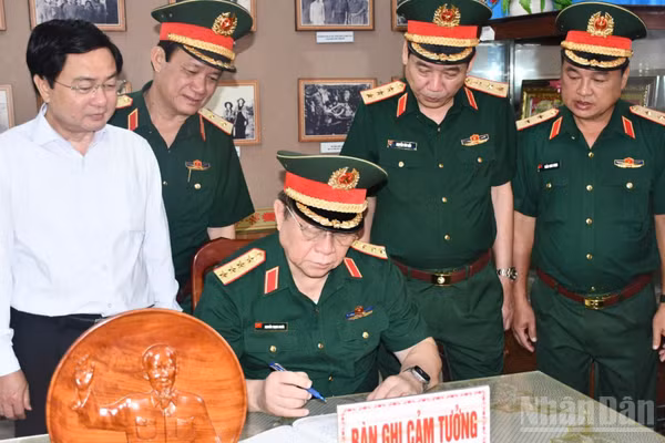 Đại tướng Nguyễn Trọng Nghĩa ghi cảm tưởng tại Nhà truyền thống Cơ quan Chính trị Quân khu 8. (Ảnh: THANH PHONG)