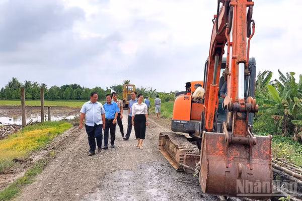 Lãnh đạo xã Tân Trụ trực tiếp kiểm tra tiến độ thi công mở rộng công trình giao thông nông thôn. (Ảnh: THANH PHONG)