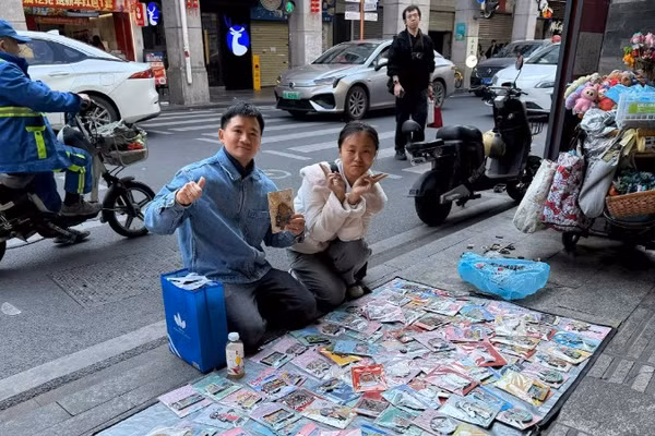 Tác giả (trái) bên một “sạp hàng” bán miếng dán tủ lạnh.