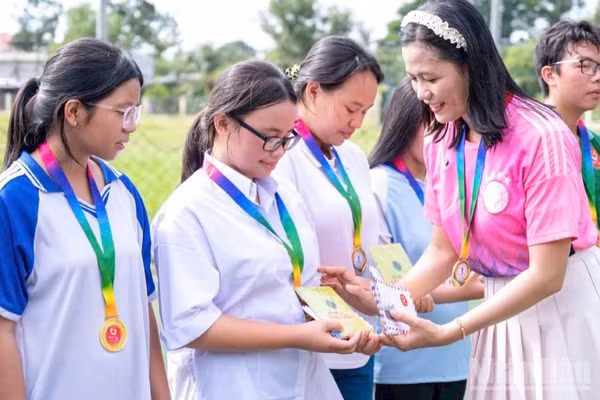 Cô Nguyễn Thị Minh Tâm, Chủ nhiệm câu lạc bộ thanh niên khuyết tật tỉnh Đồng Tháp trao quà cho học sinh có hoàn cảnh khó khăn. (Ảnh: LÝ OANH)