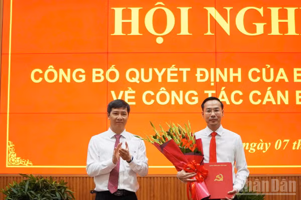 Thừa ủy quyền của Ban Bí thư, đồng chí Nguyễn Thành Tâm, Ủy viên Trung ương Đảng, Phó Trưởng Ban Tổ chức Trung ương (bên trái) trao quyết định và tặng hoa chúc mừng đồng chí Nguyễn Thanh Nhàn. (Ảnh: NGUYỄN SỰ)