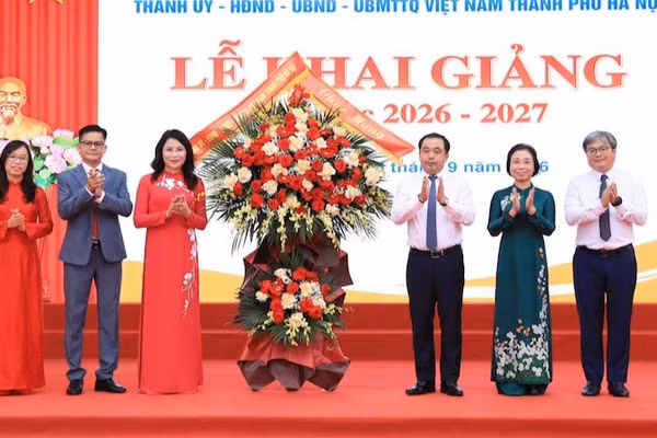 Bí thư Thành ủy Hà Nội tặng hoa chúc mừng Trường trung học cơ sở Trần Duy Hưng. (Ảnh: Thái Quang)