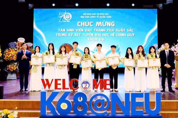 Giám đốc Đại học Kinh tế Quốc dân chúc mừng các tân sinh viên đạt thành tích xuất sắc. (Ảnh: TUẤN ANH)