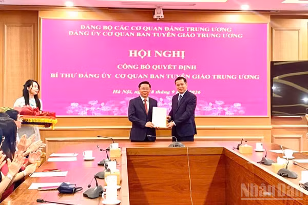 Đồng chí Nguyễn Long Hải trao Quyết định của Ban Thường vụ Đảng ủy các cơ quan Đảng Trung ương cho đồng chí Trần Thanh Lâm. (Ảnh: QUỲNH CHI)