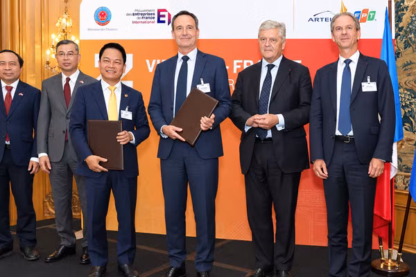 Ông Nguyễn Ngọc Nghị, Phó Tổng Giám đốc T&T Group, Chủ tịch T&T Energy Group và Ông Arnaud Lenail Chouteau, Phó Chủ tịch Cấp cao kiêm Tổng Giám đốc TotalEnergies Gas & Power Activities trao biên bản ghi nhớ về hợp tác phát triển Dự án điện khí LNG Long Sơn. (Ảnh: Anh Chiến)