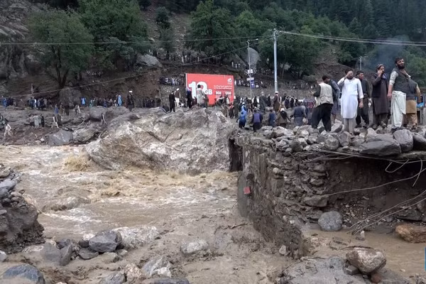 Người dân đứng trên nền những ngôi nhà bị lũ quét cuốn trôi tại tỉnh Nuristan, Afghanistan. (Ảnh: Tân Hoa xã)