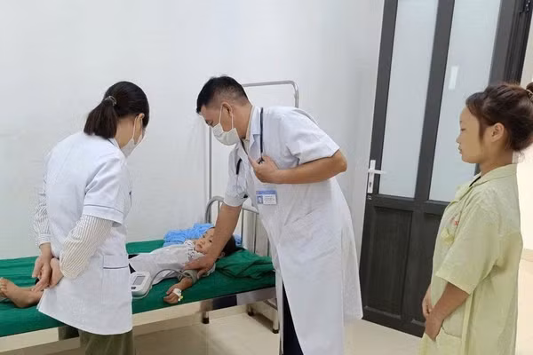 Bác sĩ ở Trung tâm Y tế Nậm Pồ khám, điều trị cho trẻ mắc bệnh quai bị. (Ảnh: LÊ LAN)