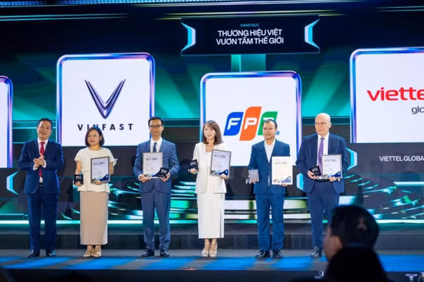 Bà Mai Thị Lan Anh, Giám đốc Truyền thông Tập đoàn FPT (thứ ba từ phải sang), nhận vinh danh “Thương hiệu Việt vươn tầm thế giới” cho Tập đoàn FPT. (Ảnh: Minh Sơn/FPT)