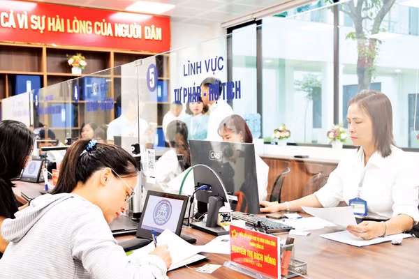 Người dân làm việc với cán bộ tiếp nhận tại bộ phận một cửa phường Đống Đa, Hà Nội. (Ảnh THẾ ĐẠI)