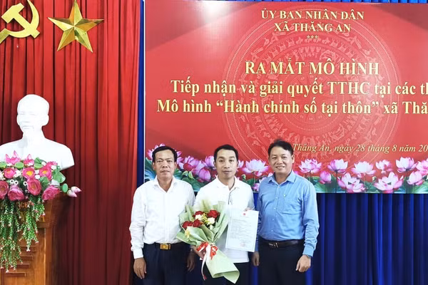 Lãnh đạo xã Thăng An trao kết quả và tặng hoa chúc mừng công dân khi thực hiện thủ tục hành chính tại buổi ra mắt mô hình. 