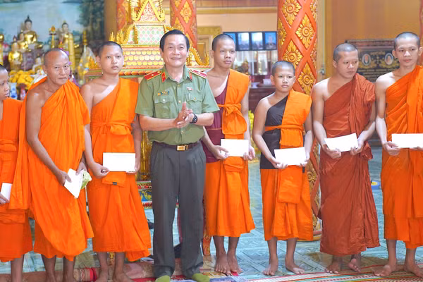 Thiếu tướng Hồ Việt Triều (đứng giữa) thay mặt lãnh đạo tỉnh tặng quà mừng lễ Sene Dolta Ban Quản trị, chức sắc, chức việc Chùa Ngan Dừa, xã Hồng Dân, tỉnh Cà Mau. (Ảnh: HỮU ĐỆ)