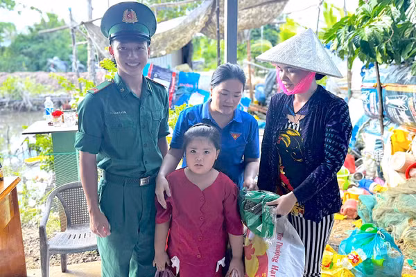 Cán bộ, chiến sĩ Đồn Biên phòng Rạch Gốc và Đoàn thanh niên địa phương đổi rác lấy quà cho người dân. (ảnh HOÀNG TÁ).