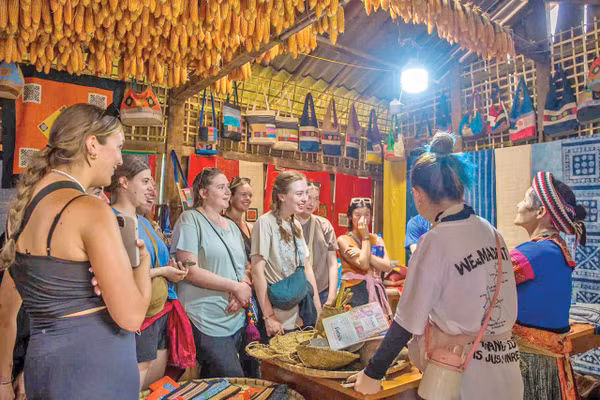 Du khách nước ngoài thích thú với những sản phẩm vải lanh của Lùng Tám. 