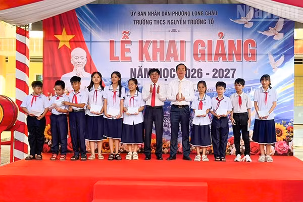 Chủ tịch Ủy ban nhân dân tỉnh Vĩnh Long Trần Trí Quang trao học bổng cho học sinh Trường trung học cơ sở Nguyễn Trường Tộ. (Ảnh: BÁ DŨNG)
