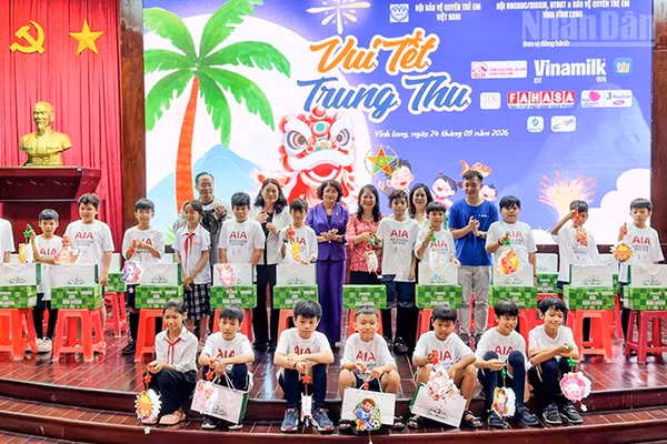 Đồng chí Đặng Thị Ngọc Thịnh, nguyên Ủy viên Trung ương Đảng, nguyên Phó Chủ tịch nước cùng nhà tài trợ trao quà cho các em thiếu nhi. (Ảnh: BÁ DŨNG)