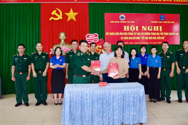 Đại diện chỉ huy Đồn Biên phòng Tuy Hòa và Trường trung học phổ thông Nguyễn Huệ ký chương trình kết nghĩa. (Ảnh: NGUYỄN LÂN)