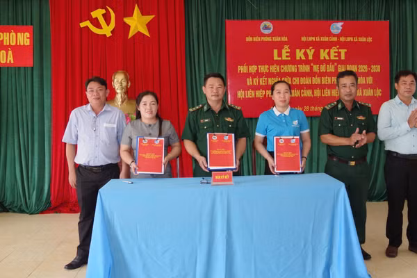 Đại diện Đồn Biên phòng Xuân Hòa và Hội Liên hiệp Phụ nữ 2 xã Xuân Cảnh và Xuân Lộc ký kết chương trình phối hợp. (Ảnh: NGUYỄN LÂN)