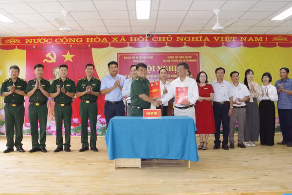 Lãnh đạo Ban Chỉ huy Bộ đội Biên phòng tỉnh Đắk Lắk và Trường phổ thông nội trú tiểu học và trung học cơ sở Buôn Đôn trao biên bản ký kết kết nghĩa. (Ảnh: DÂN QUÂN)