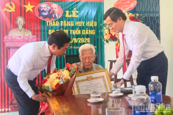 Đồng chí Đoàn Minh Huấn, Ủy viên Bộ Chính trị, Giám đốc Học viện Chính trị quốc gia Hồ Chí Minh cùng lãnh đạo thành phố Cần Thơ trao Huy hiệu 80 năm tuổi Đảng cho đồng chí Phạm Duy Khương. (Ảnh: VĂN ÚT)